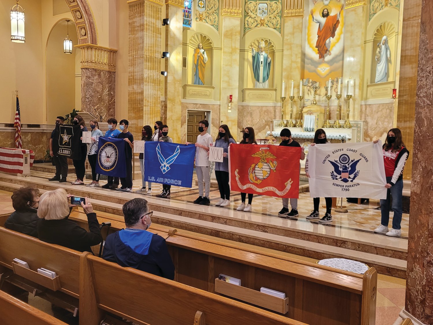 St. Rocco students helped carry five other flags, each representing a branch of the military — the U.S. Army, Navy, Marine Corps, Air Force and Coast Guard — to the front of the church.